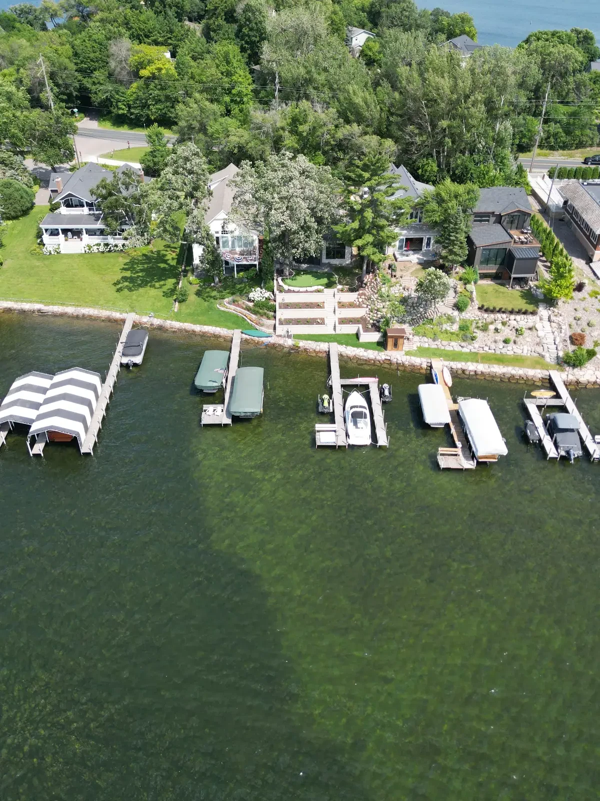 Aerial view of completed lakeside renovation with retaining walls, landscaping, and docks on Lake Minnetonka in Excelsior, MN