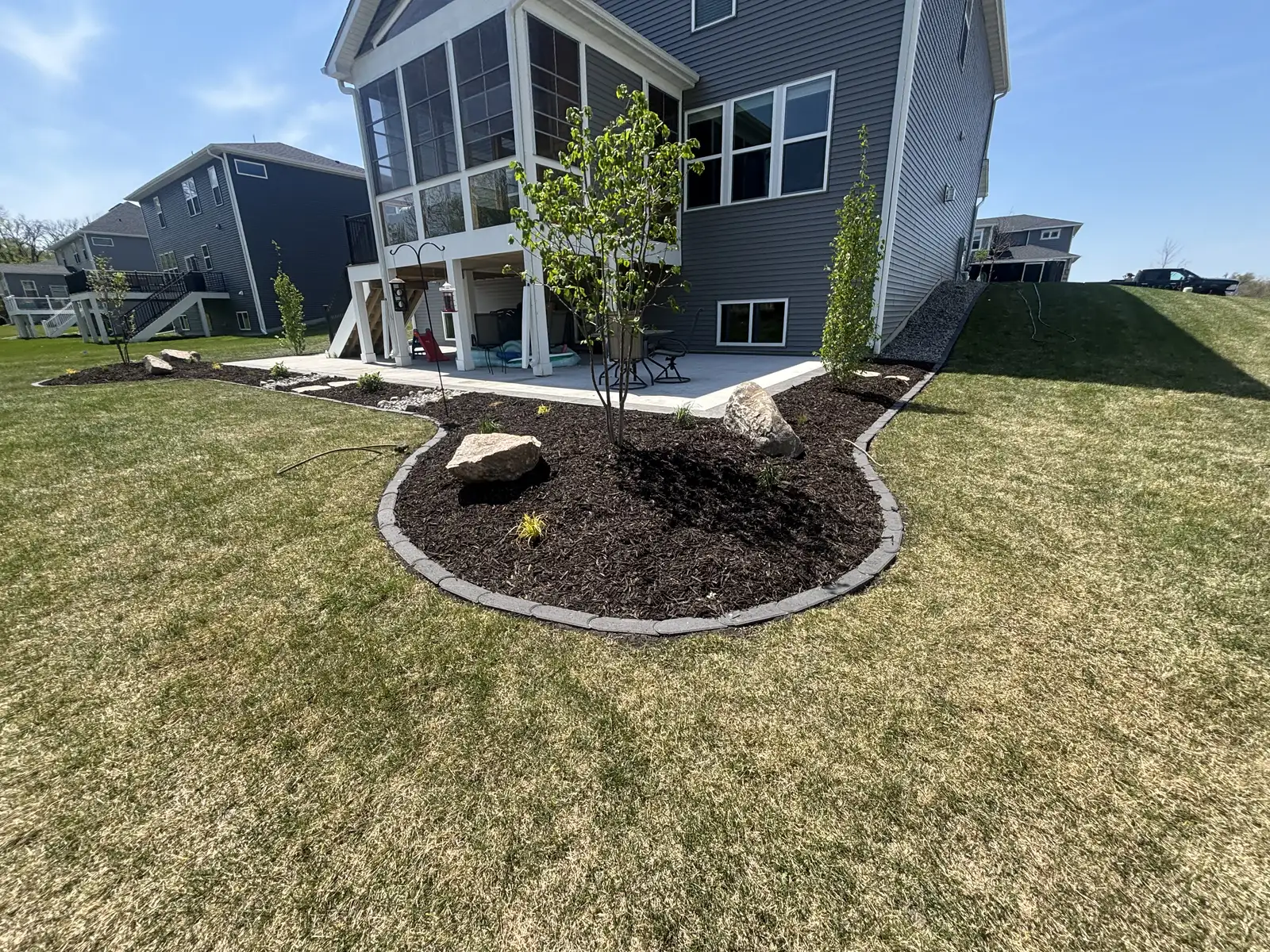 Granite rock bed and boulder outcroppings installed around home foundation in Medina, MN